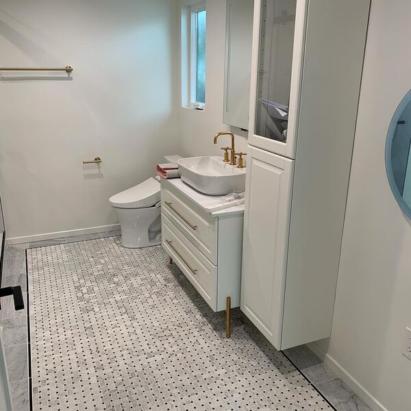 Bathroom in Arcadia with a marble basket weave floor and brass fixtures