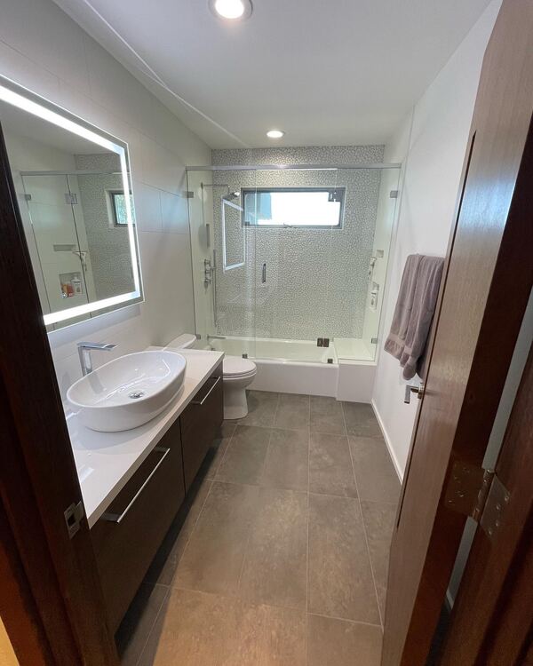 Remodeled bathroom in Glendale with a vessel sink and lit mirror