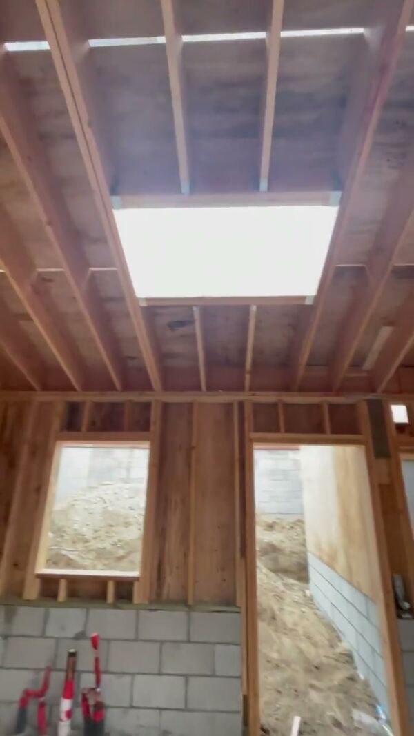 Inside the framed ADU, with a vaulted ceiling and a skylight